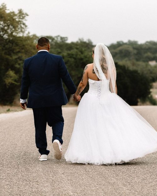 bride and groom walking down street holding hands after intimate ceremony