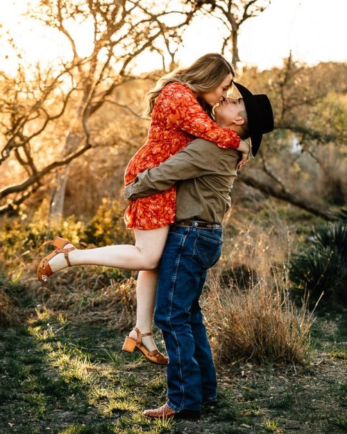 golden hour engagement photo session lifting fiancée