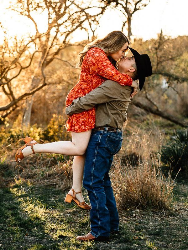 golden hour engagement photo session lifting fiancée