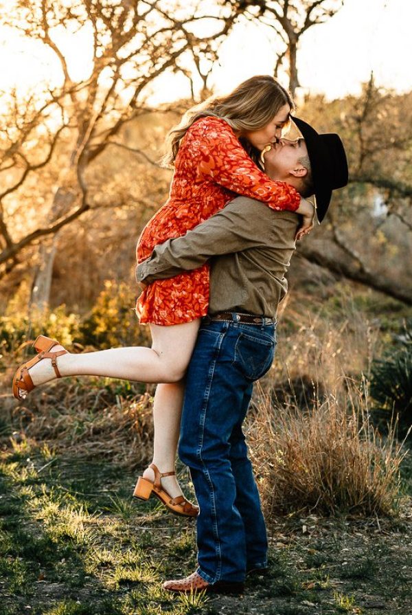 golden hour engagement photo session lifting fiancée